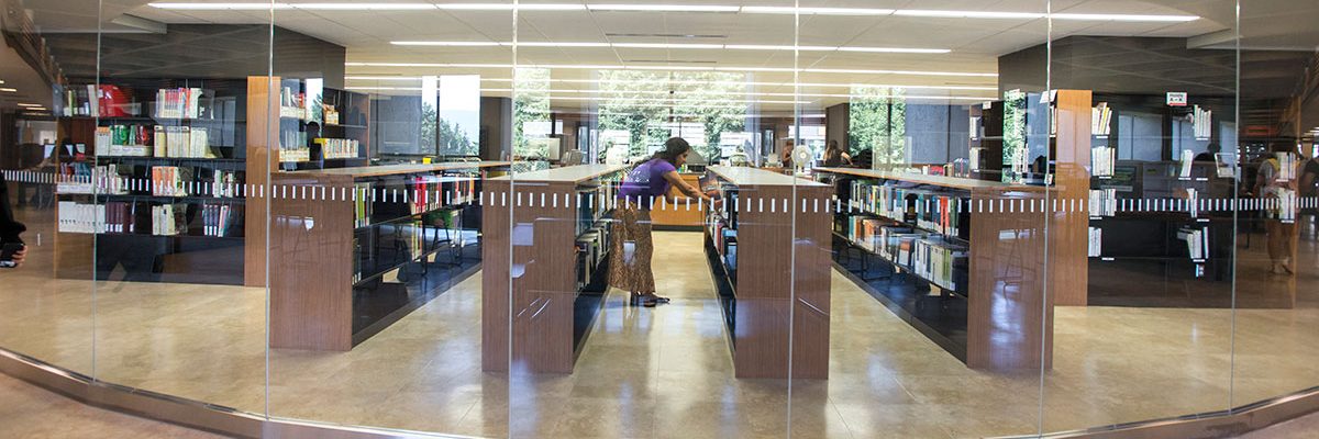 A library staff retrieves an item from the central reserves area in the Bennett Library at Simon Fraser University
